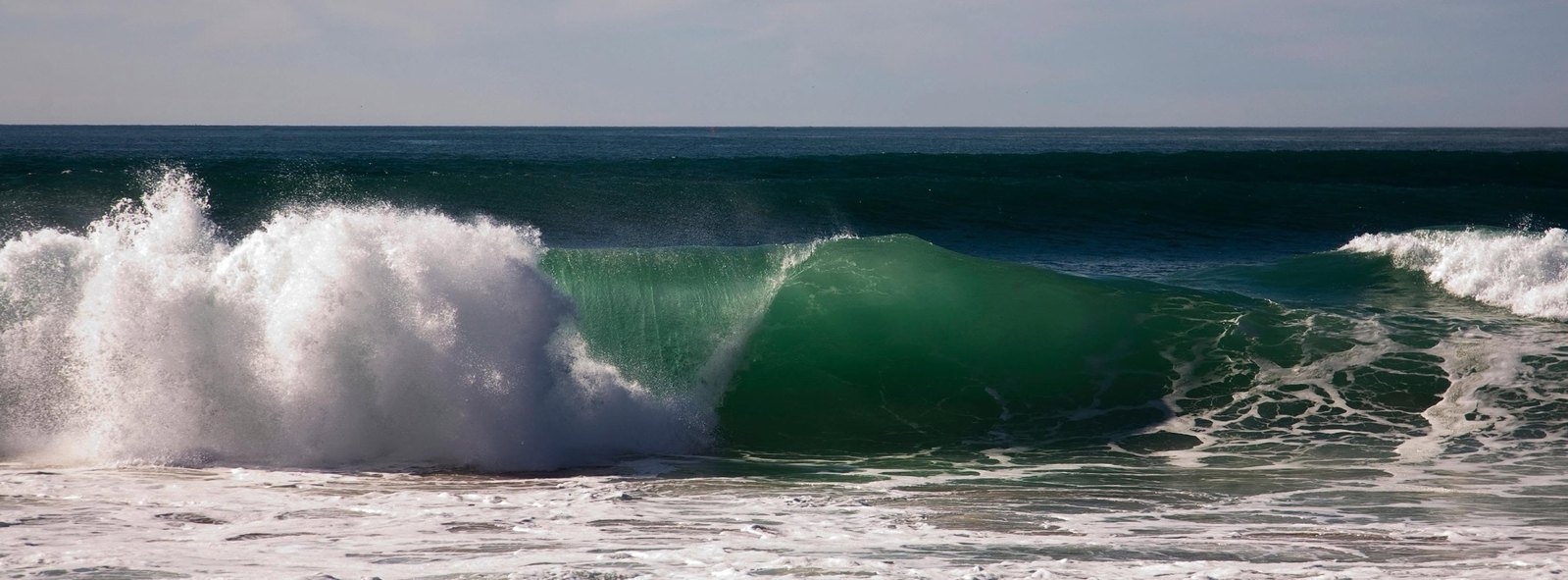 Photograph of a wave curling at the shoreline