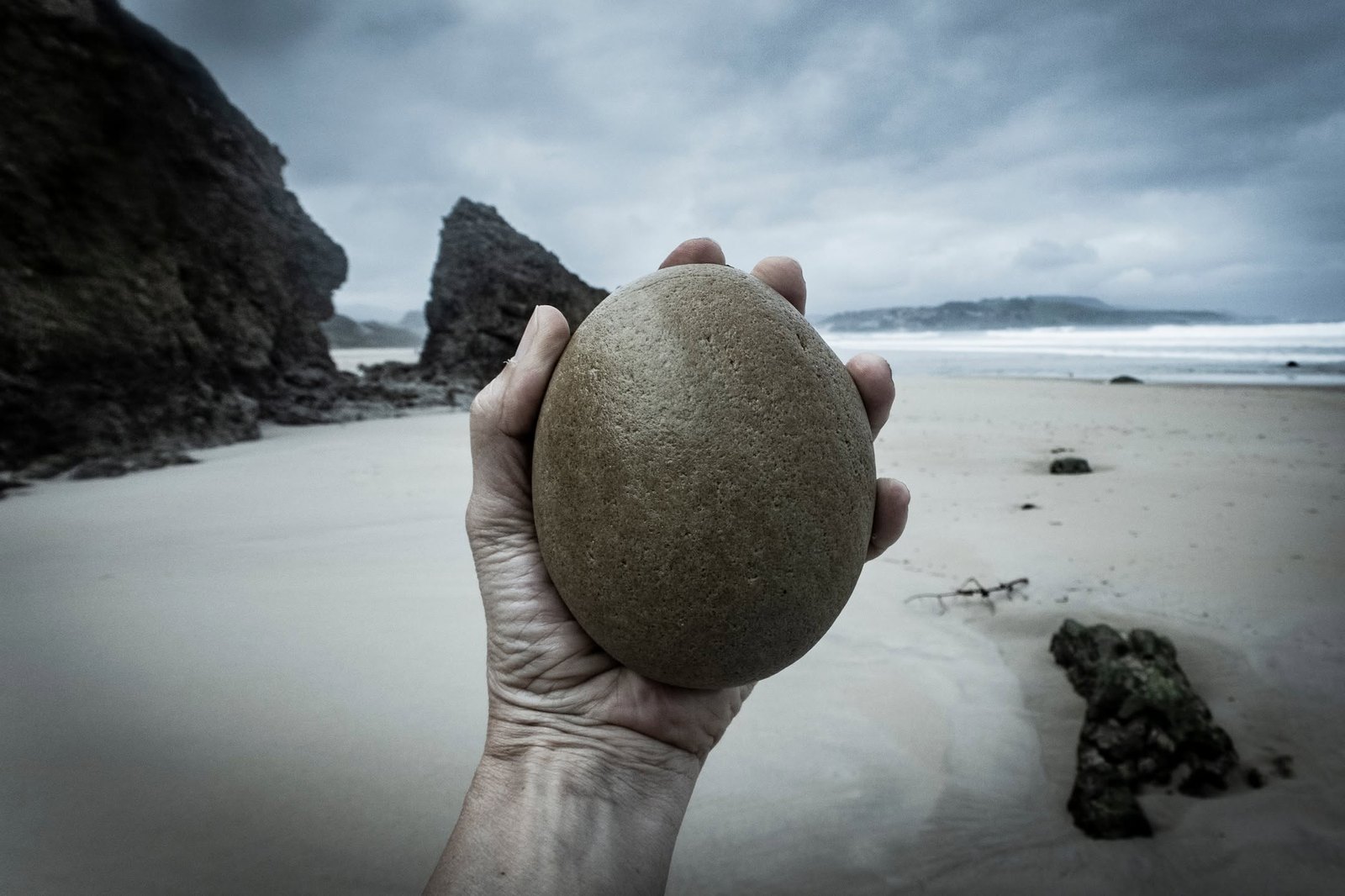 Photograph of a hand resting against stone