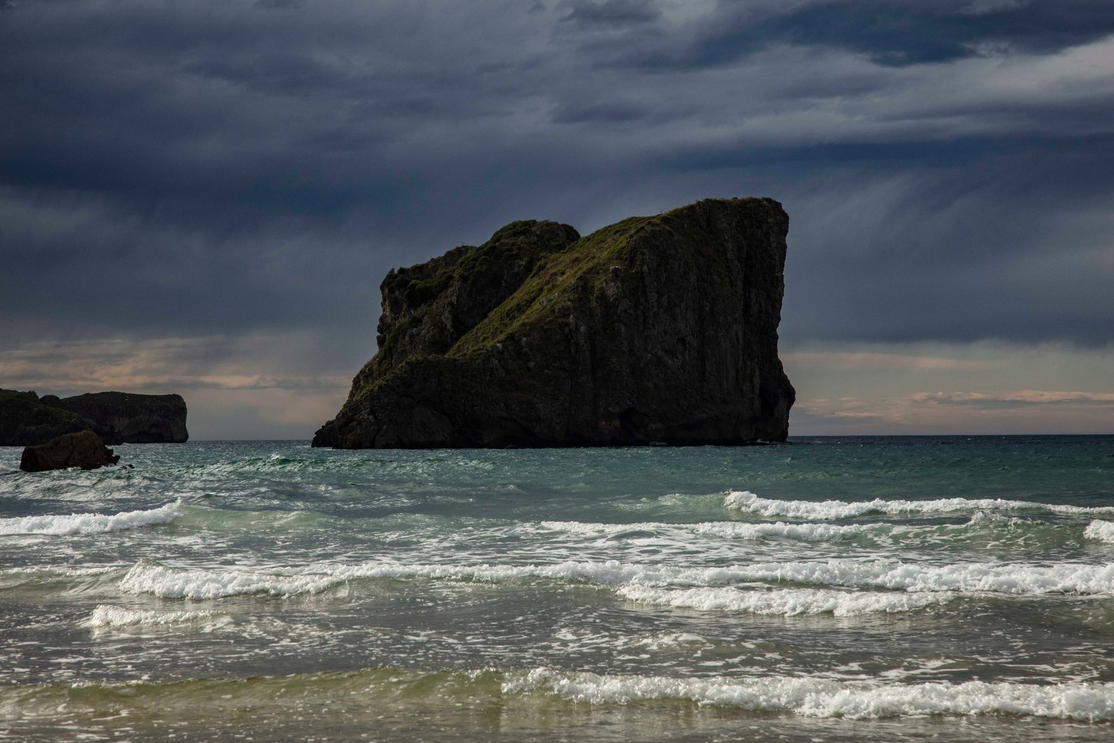 Photograph of stormy waves breaking against rock
