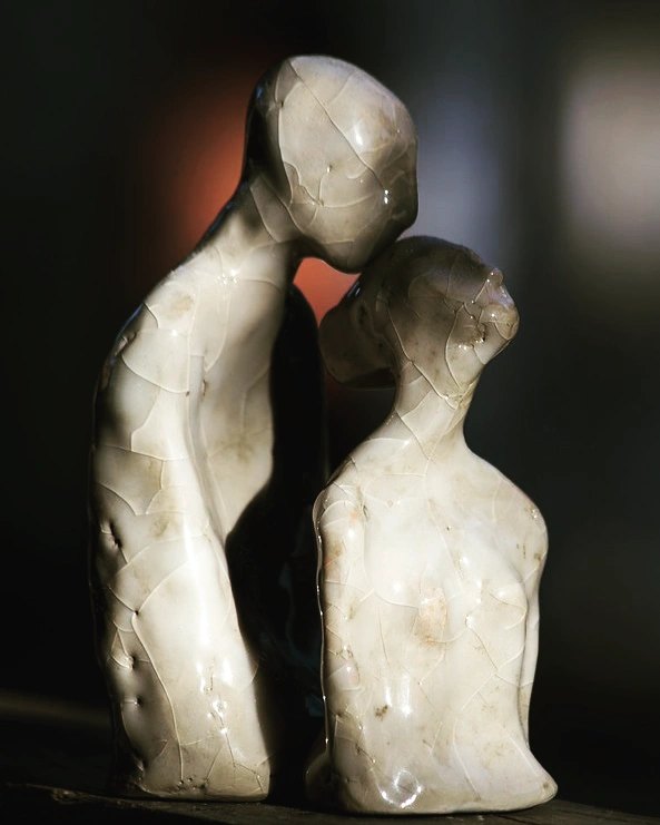 Crackle-glazed ceramic sculpture of two embracing figures